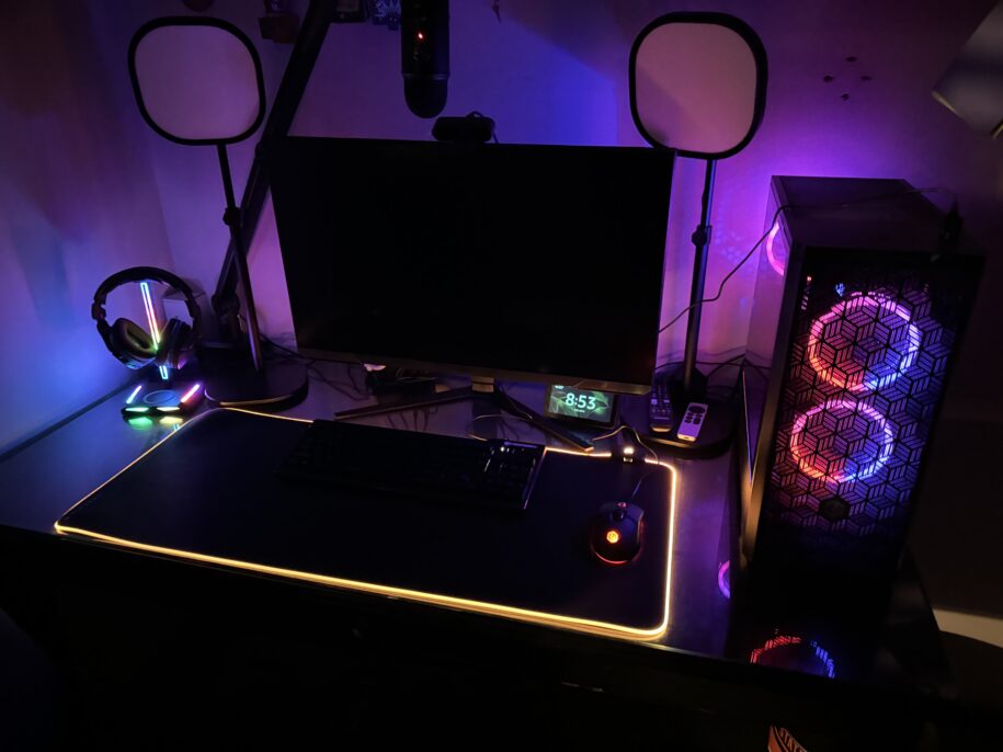 black gaming desktop with blue and purple lights in a dark room