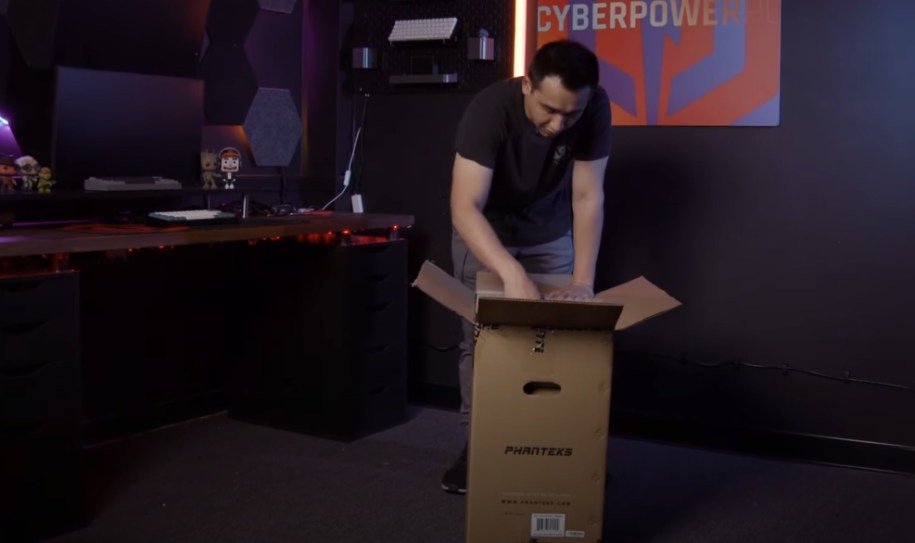 Man opening a brown box containing a a gaming pc