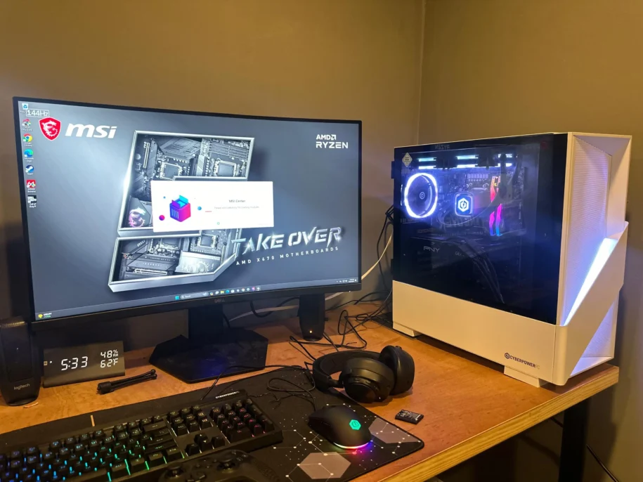 White gaming Pc with a white light illuminating it across the center sitting on top of a wooden desk.